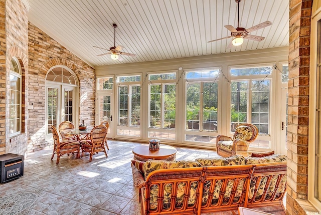 sunroom / solarium with vaulted ceiling, a wealth of natural light, wooden ceiling, and ceiling fan