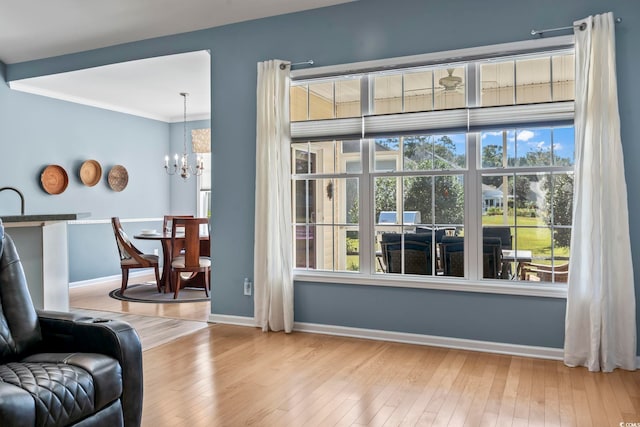 interior space featuring a wealth of natural light, a chandelier, light wood-type flooring, and ornamental molding