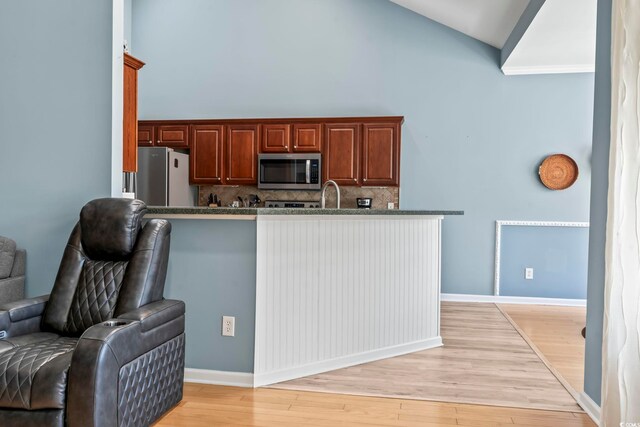 living room featuring ceiling fan, light hardwood / wood-style flooring, and high vaulted ceiling