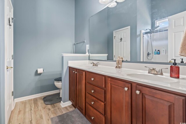 bedroom featuring light hardwood / wood-style floors, ceiling fan, connected bathroom, and vaulted ceiling