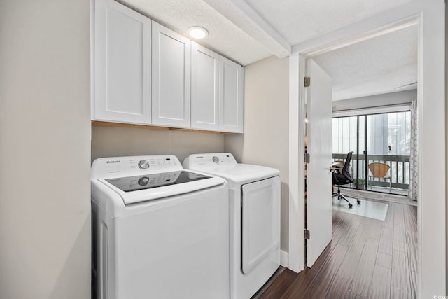 laundry room with washing machine and dryer, dark hardwood / wood-style floors, cabinets, and a textured ceiling