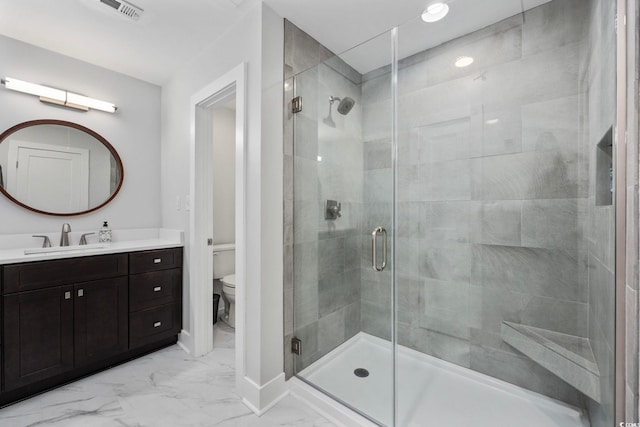 bathroom with vanity, toilet, and an enclosed shower