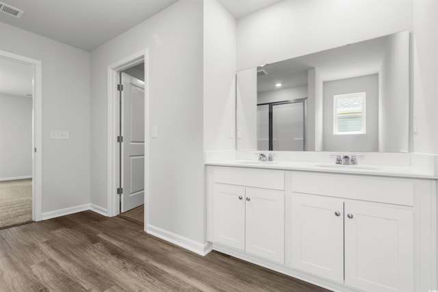 bathroom featuring vanity, a shower with shower door, and wood-type flooring