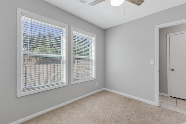 unfurnished room featuring light carpet, a wealth of natural light, and ceiling fan