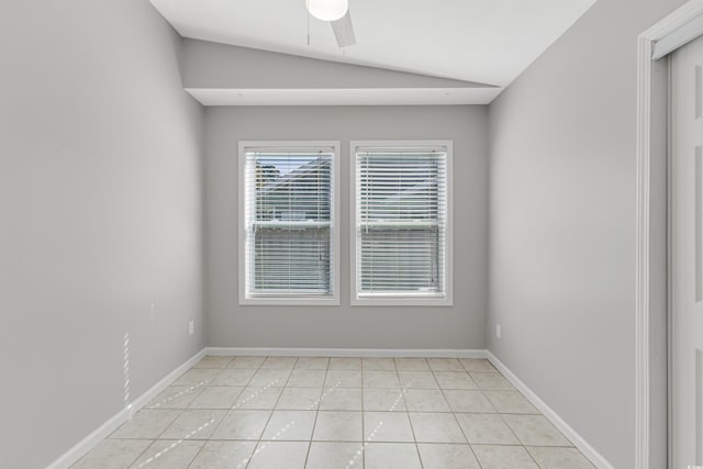 empty room featuring light tile patterned floors, vaulted ceiling, and ceiling fan