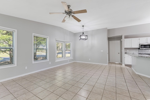 unfurnished living room featuring vaulted ceiling, light tile patterned flooring, and ceiling fan with notable chandelier