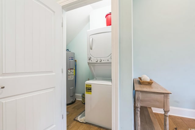 washroom with stacked washer / drying machine, electric water heater, and light wood-type flooring