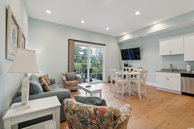 living room featuring sink and light hardwood / wood-style flooring