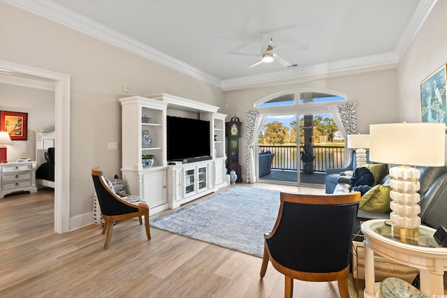 living room featuring ornamental molding, light wood-type flooring, and ceiling fan