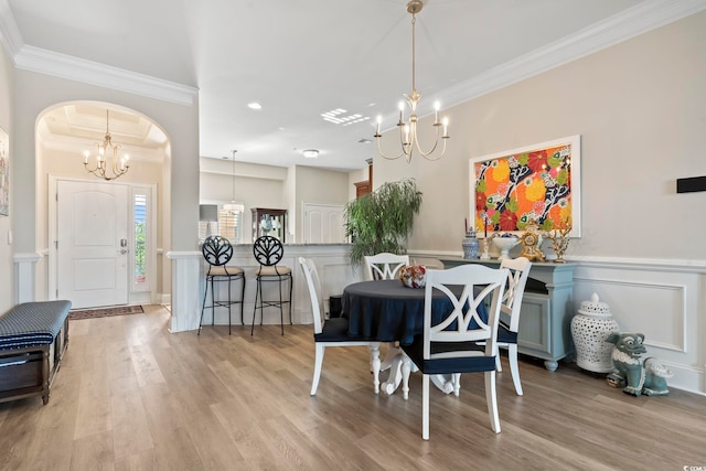 dining area with ornamental molding and light hardwood / wood-style floors