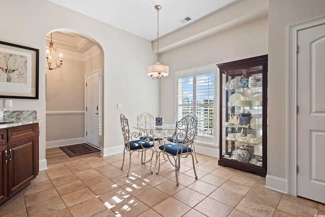 dining space featuring crown molding and a notable chandelier