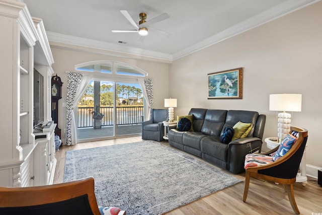 living room with light hardwood / wood-style floors, ornamental molding, and ceiling fan