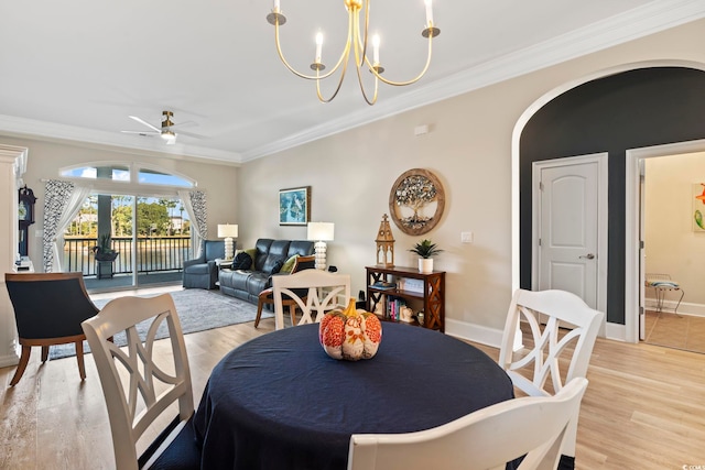 dining area with light hardwood / wood-style floors, ornamental molding, and ceiling fan with notable chandelier