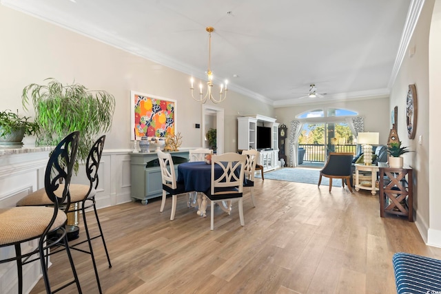 dining space featuring ornamental molding, ceiling fan with notable chandelier, and light hardwood / wood-style floors