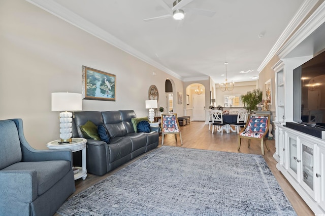 living room featuring ornamental molding, light hardwood / wood-style flooring, and ceiling fan with notable chandelier