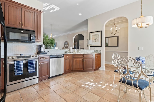 kitchen with decorative backsplash, hanging light fixtures, sink, light stone countertops, and appliances with stainless steel finishes