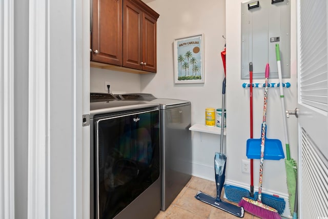 washroom featuring independent washer and dryer, light tile patterned floors, and cabinets