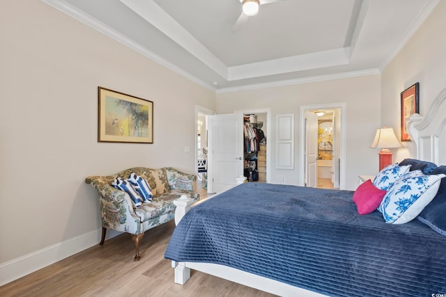 bedroom featuring a closet, ensuite bath, a spacious closet, hardwood / wood-style floors, and ceiling fan