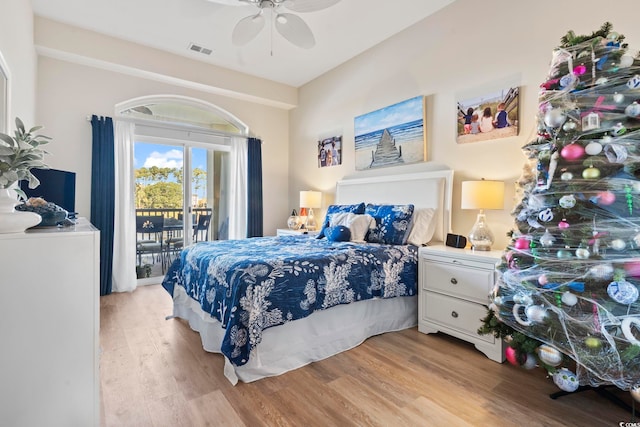 bedroom featuring access to exterior, light hardwood / wood-style floors, and ceiling fan