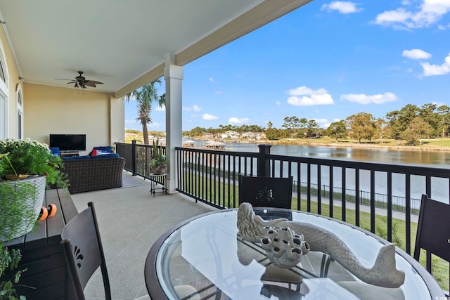 balcony with a water view, ceiling fan, and an outdoor living space