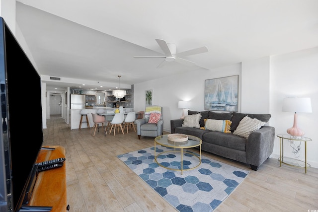 living room with light wood-type flooring and ceiling fan