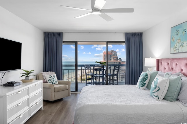 bedroom featuring a water view, ceiling fan, access to outside, and dark hardwood / wood-style floors