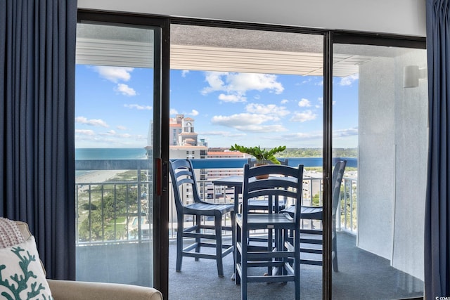 dining space with a water view and carpet floors