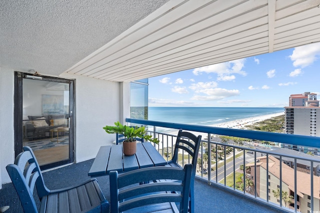 balcony with a water view and a beach view