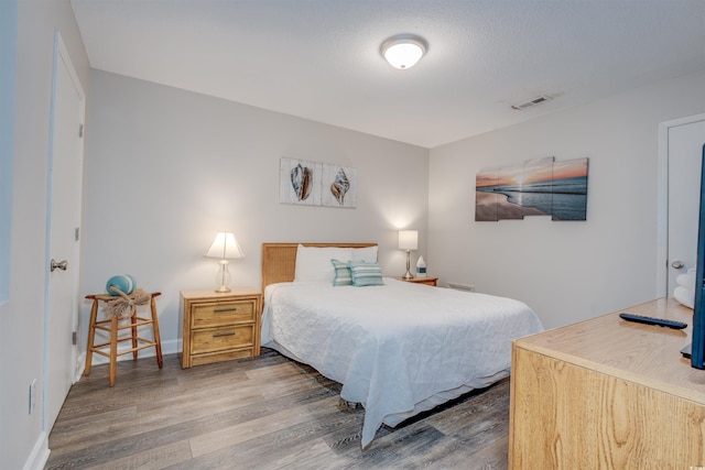 bedroom with dark hardwood / wood-style floors