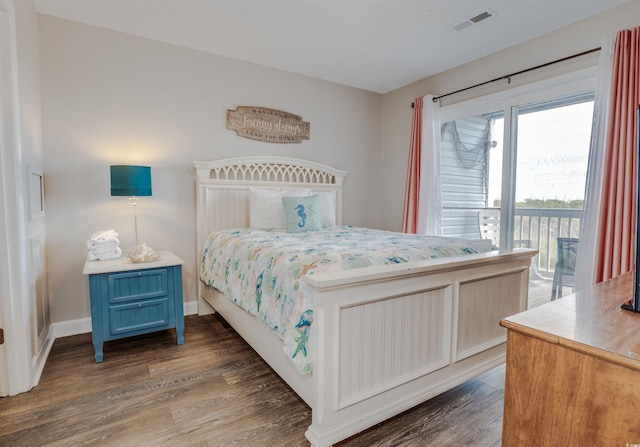 bedroom with dark hardwood / wood-style floors and access to exterior