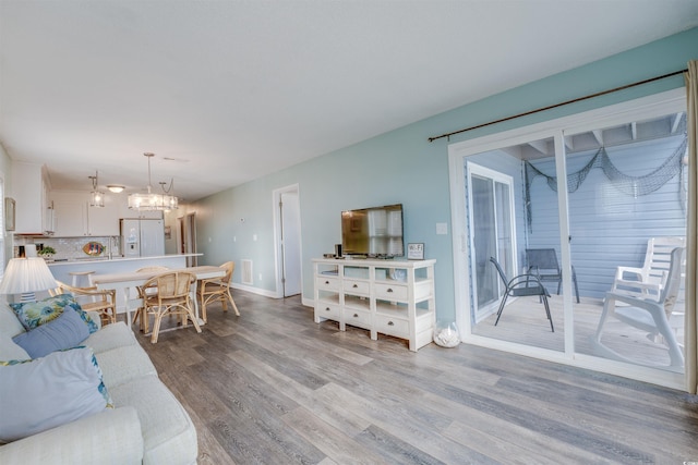 living room with light hardwood / wood-style flooring and a notable chandelier