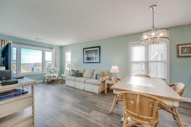 dining space featuring a wealth of natural light, hardwood / wood-style floors, and a notable chandelier