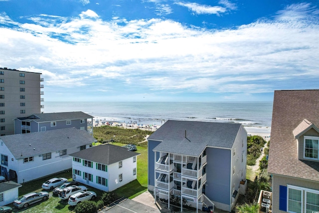 birds eye view of property featuring a water view and a beach view