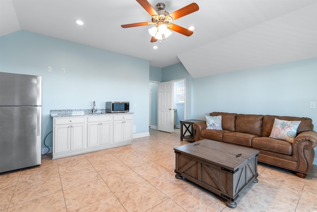 tiled living room with ceiling fan and vaulted ceiling