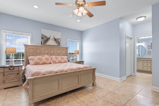 bedroom with multiple windows, light tile patterned flooring, connected bathroom, and ceiling fan