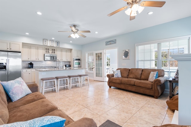 tiled living room featuring sink and ceiling fan