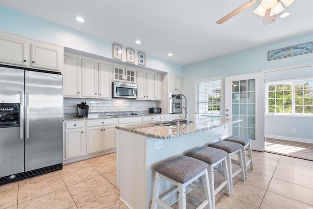 kitchen featuring a healthy amount of sunlight, stainless steel appliances, and white cabinets