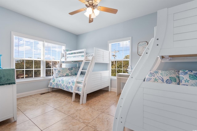 bedroom with ceiling fan, multiple windows, and light tile patterned floors