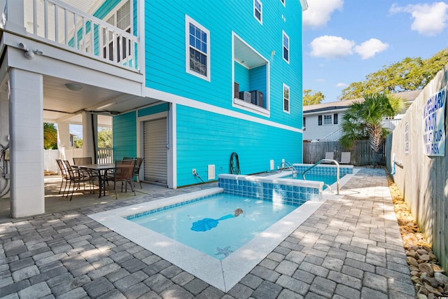 view of pool with an in ground hot tub and a patio area