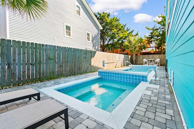 view of swimming pool featuring a patio and an in ground hot tub