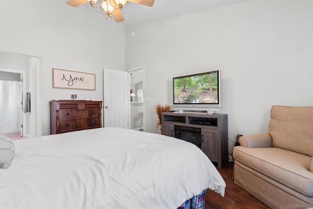 bedroom with ceiling fan, dark wood-type flooring, a high ceiling, and ensuite bath