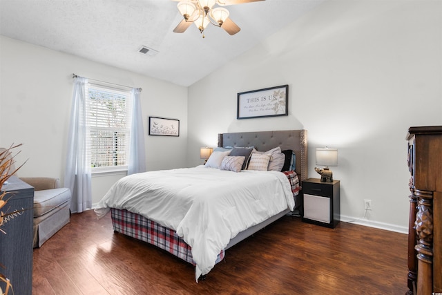 bedroom with a textured ceiling, ceiling fan, dark hardwood / wood-style flooring, and vaulted ceiling