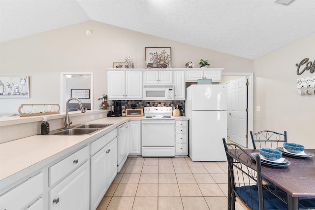 kitchen with lofted ceiling, sink, white cabinets, and white appliances