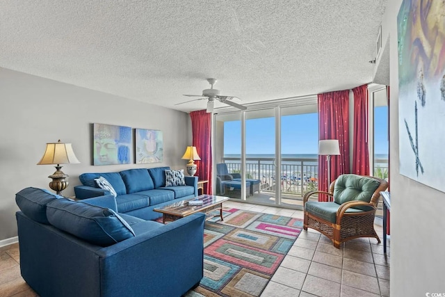 living room featuring a wall of windows, a textured ceiling, a water view, and ceiling fan