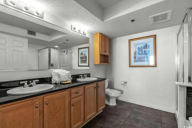 bathroom with toilet, tile patterned flooring, vanity, a textured ceiling, and an enclosed shower