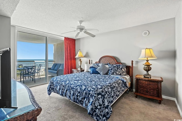 carpeted bedroom with a water view, ceiling fan, access to outside, and a textured ceiling