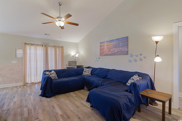 living room with ceiling fan, wood-type flooring, and vaulted ceiling