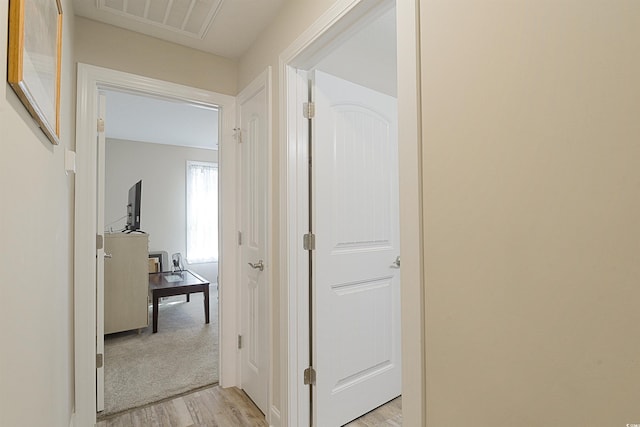 hallway with light hardwood / wood-style floors