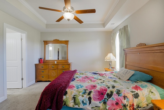 bedroom with a tray ceiling, ceiling fan, light carpet, and ornamental molding