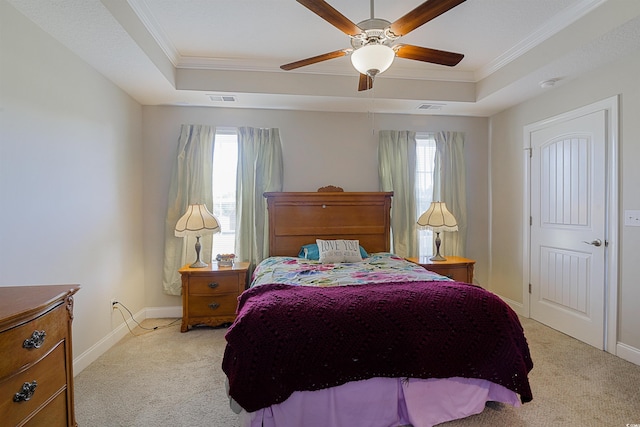 bedroom with a raised ceiling, ceiling fan, light colored carpet, and ornamental molding